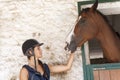 Young horsewoman with its horses in the stable Royalty Free Stock Photo