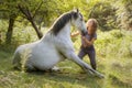 A young horsewoman shows a trick with her horse trained with natural dressage, introducing us in the world of the horsemanship Royalty Free Stock Photo