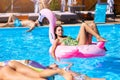 Young hot girl in bikini relaxing and chilling on inflatable pink flamingo pool float. Pretty tanned woman in swimsuit
