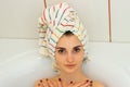 Young hot girl with a towel on her head lies in the bathroom and looks into the camera Royalty Free Stock Photo