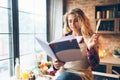 Young housewife in an apron reads recipe book Royalty Free Stock Photo