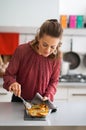 Young housewife cooking baked pumpkin