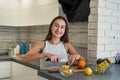 Young housewife cutting  fruits on wooden board while making healthy food for breakfest Royalty Free Stock Photo