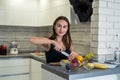 Young housewife cutting  fruits on wooden board while making healthy food for breakfest Royalty Free Stock Photo