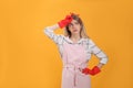 Young housewife in gloves on yellow background. Space for text Royalty Free Stock Photo