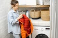 Young housewife looks on a down jacket before washing Royalty Free Stock Photo