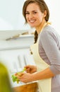 Young housewife mixing salad in modern kitchen Royalty Free Stock Photo