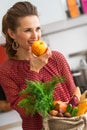 Young housewife with purchases from local market eating apple Royalty Free Stock Photo