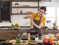 Young housewife putting pepper on the steak. Morning atmosphere in a modern kitchen