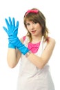 Young housewife putting on rubber gloves