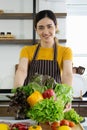 Young housewife smiled and offered a basket full of various kinds of vegetables on the front