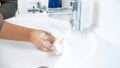 Young housewife washing bathroom sink with detergent Royalty Free Stock Photo