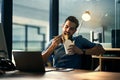 Young hungry businessman working late and eating at desk. Man having takeout food in the office at work station in the Royalty Free Stock Photo