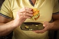 Young hungry man eating a burger . The guy eats fast food, unhealthy food. Diet concept Royalty Free Stock Photo