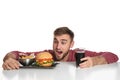 Young hungry man with glass of cola, tasty burger and French fries