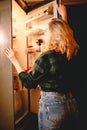 Young hungry woman looking in fridge at night at home Royalty Free Stock Photo