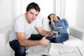 Young husband cutting credit card with scissors woman depressed