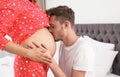 Young husband kissing his pregnant wife`s tummy Royalty Free Stock Photo