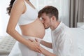 Young husband kissing his pregnant wife`s tummy Royalty Free Stock Photo