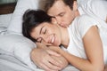 Young husband waking up wife kissing and hugging her Royalty Free Stock Photo