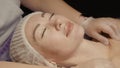 Woman receiving anti-ageing facial massage in spa salon relax. Wellness body skin care face beauty treatment. Black Royalty Free Stock Photo