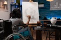 Young illustrator in wheelchair drawing artistic vase ilustration