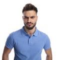 Young imature man wearing a light blue polo frowning Royalty Free Stock Photo