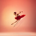 Young and incredibly beautiful ballerina is posing and dancing at red studio full of light. Royalty Free Stock Photo