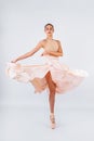 A young and incredibly beautiful ballerina is posing and dancing in a white studio full of light. The beauty of classical ballet Royalty Free Stock Photo