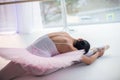 Young and incredibly beautiful ballerina is posing and dancing in a white studio full of light.