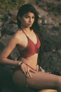 Young India girl in red bikini enjoying her vacation on beach and relaxing on beach