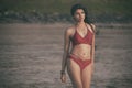 Young India girl in red bikini enjoying her vacation on beach and relaxing on beach