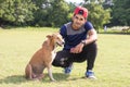 Young Indian athlete man playing with dog and looking at camera in sports ground while jogging. Male Sports and fitness concept.