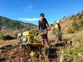 A young Indian boy driving mini tractor for wheat cultivation in terraced field, Land cultivation with rototiller.