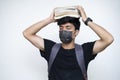 Young Indian boy holding books on his head, wearing mask, and getting ready for college after the corona virus lockdown is over Royalty Free Stock Photo