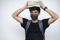 Young Indian boy holding books on his head, wearing mask, and getting ready for college after the corona virus lockdown is over Royalty Free Stock Photo