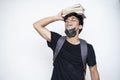 Young Indian boy holding books on his head, wearing mask, and getting ready for college after the corona virus lockdown is over Royalty Free Stock Photo