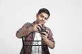 Young indian boy listening music and using smartphone on white background Royalty Free Stock Photo