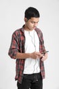 Young indian boy listening music and using smartphone on white background Royalty Free Stock Photo