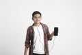 Young indian boy listening music and using smartphone on white background Royalty Free Stock Photo