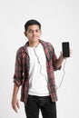 Young indian boy listening music and using smartphone on white background Royalty Free Stock Photo