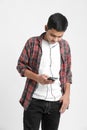 Young indian boy listening music and using smartphone on white background Royalty Free Stock Photo