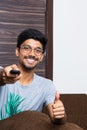 Young indian boy pointing the television remote and smiling Royalty Free Stock Photo