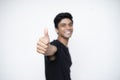 Young Indian boy showing thumbs up to the camera standing on a white isolated background