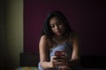 Young Indian brunette woman in sleeping wear sitting on a bed Royalty Free Stock Photo