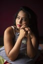 Young Indian brunette woman in sleeping wear sitting on a bed Royalty Free Stock Photo