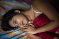 Young Indian brunette woman in white sleeping wear sleeping on a bed Royalty Free Stock Photo