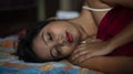 Young Indian brunette woman in white sleeping wear sleeping on a bed Royalty Free Stock Photo