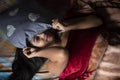 Young Indian brunette woman in white sleeping wear sleeping on a bed Royalty Free Stock Photo