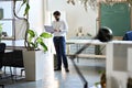 Young indian business man manager working on laptop standing in office space. Royalty Free Stock Photo